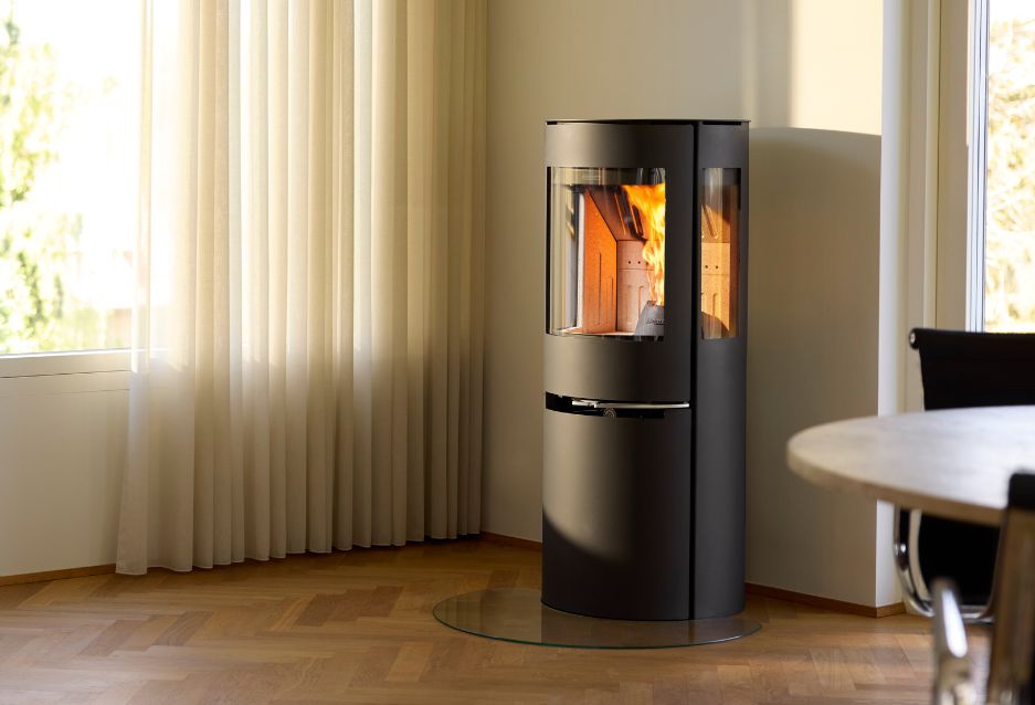 Hybridovn med sideglas står og brænder med piller i stue