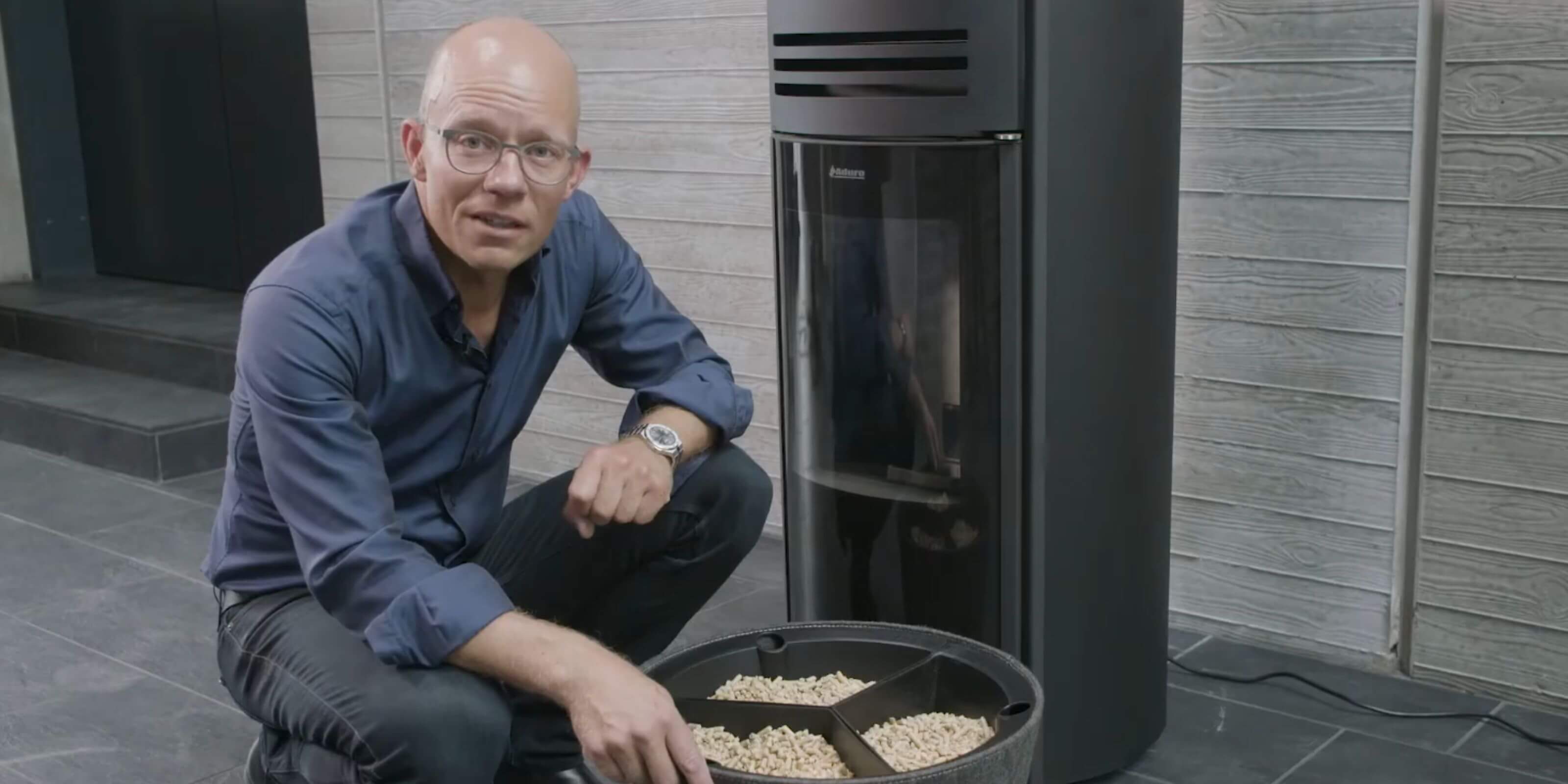 Stilbillede af person, der forklarer om Aduro pilleovn