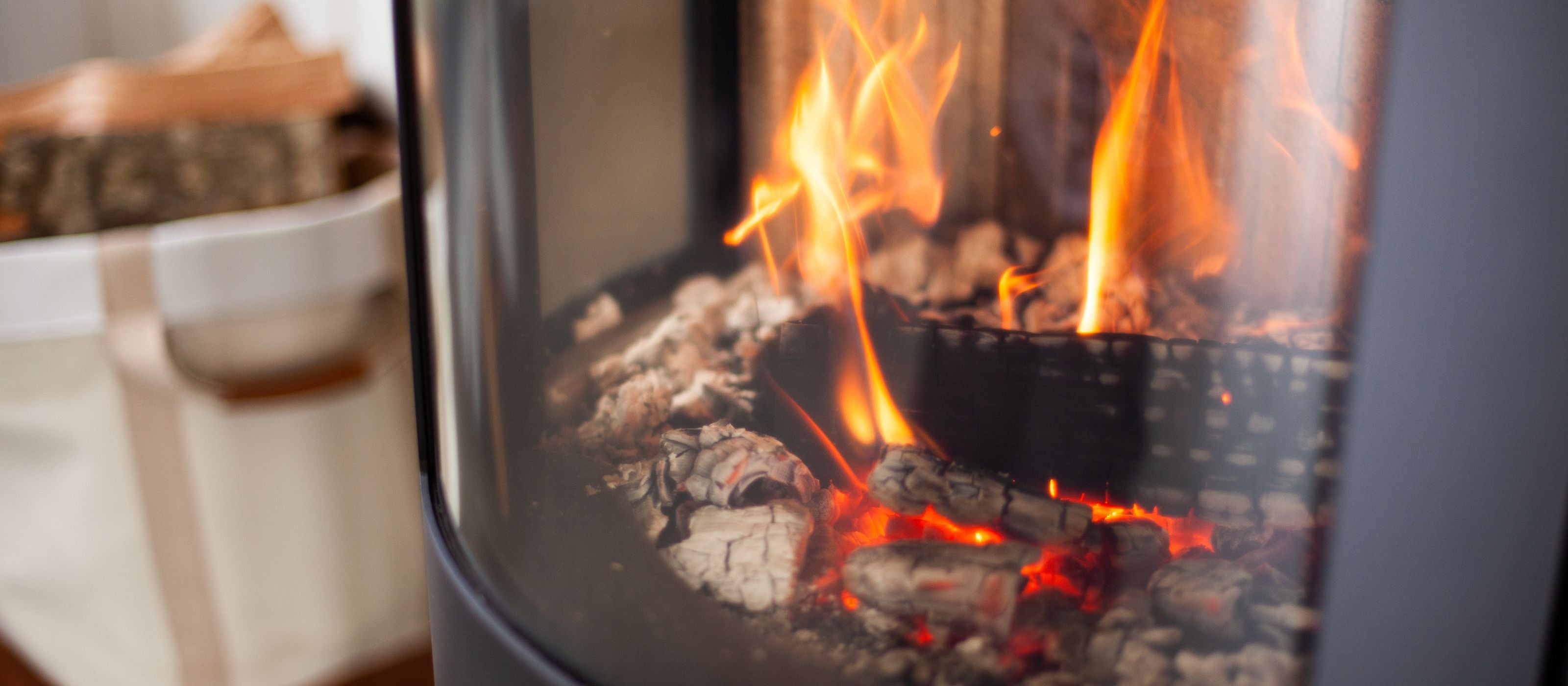 Et nærbillede af brændeovn med flammer og gløder i